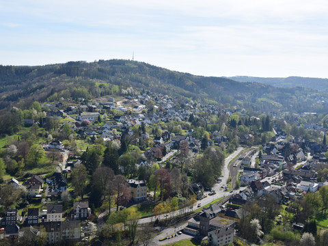 Blick vom Haldyturm  Engelskirchen: Panoramablick auf grüne Hügel und dichte Wohnsiedlungen unter klarem Himmel.