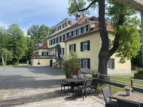 Schloss Eulenbroich Das Bild zeigt eine historische Villa im Grünen mit repräsentativer Architektur und mehreren Etagen.