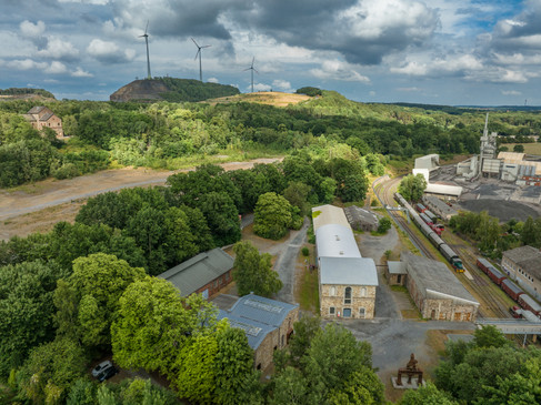 Industriegelände am grünen Piesberg, Osnabrück, mit Windkraftanlagen und historischer Architektur.
