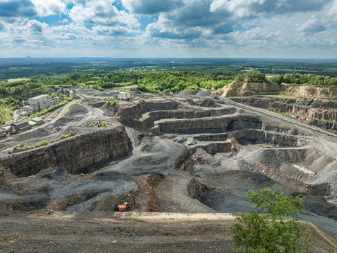 Kultur- und Landschaftspark Piesberg Het Cultuur- en Landschapspark Piesberg: een uitgestrekte steengroeve met groene zones en paden.