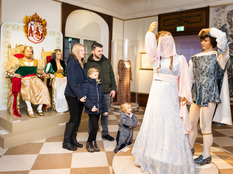 Familie betrachtet im Schloss Moritzburg Kostüme und Figuren aus "Drei Haselnüsse für Aschenbrödel".Family looks at costumes and figures from "Three Hazelnuts for Cinderella" at Moritzburg Castle.Rodina si na zámku Moritzburg prohlíží kostýmy a postavy z pohádky Tři oříšky pro Popelku.Rodzina ogląda kostiumy i figury z "Trzech orzechów laskowych dla Kopciuszka" na zamku Moritzburg.Familie bekijkt kostuums en figuren van "Drie hazelnoten voor Assepoester" op Kasteel Moritzburg.Una famiglia osserva i costumi e le figure di "Tre nocciole per Cenerentola" al Castello di Moritzburg.