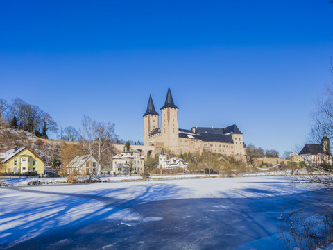 Rochlitz Castle in winter - Castles in the Leipzig region General view of Rochlitz Castle in snow with the frozen Mulde in the foreground, Mulde Cycle Path, Luther Trail Saxony