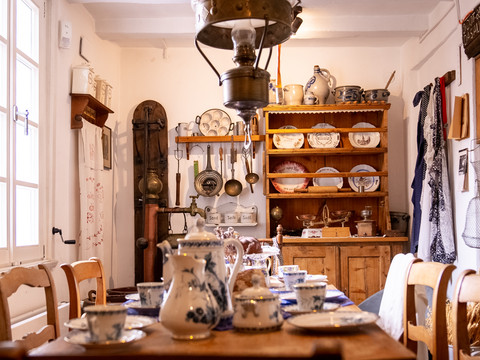 Heimatmuseum  Alte Küche mit Geschirr, Töpfen, traditionellem Charme und blauen Dekorelementen im Landhausstil.