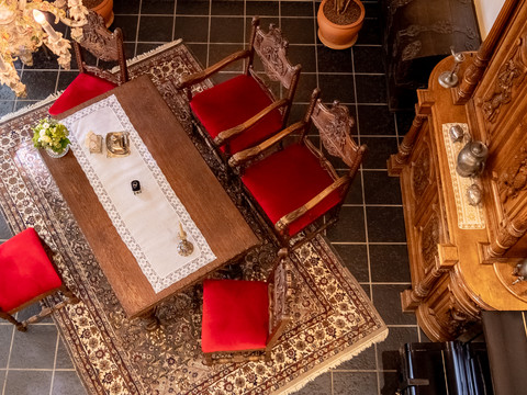 Heimatmuseum <p>Elegantes Esszimmer mit Holztisch, roten Stühlen und antikem Schrank auf gemustertem Teppich.</p>
