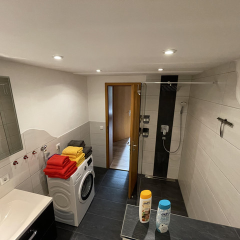 Blick ins Bad mit Waschmaschine und Dusche
