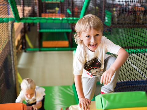 Tobeland Solivital Sebnitz Zwei Kinder klettern fröhlich in einem bunten Indoor-Spielplatz mit Netzen und weichen Kletterelementen.Two children are happily climbing in a colorful indoor playground with nets and soft climbing elements.Dvě děti spokojeně lezou na barevném vnitřním hřišti se sítěmi a měkkými lezeckými prvky.Dwoje dzieci radośnie wspina się na kolorowym krytym placu zabaw z siatkami i miękkimi elementami wspinaczkowymi.Twee kinderen klimmen vrolijk in een kleurrijke binnenspeeltuin met netten en zachte klimelementen.Due bambini si arrampicano felicemente in un colorato parco giochi al coperto con reti ed elementi morbidi per l'arrampicata.