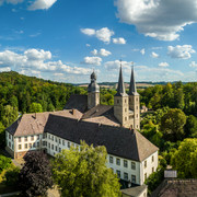 Marienmuenster-Abtei Marienmuenster-Teutoburger-Wald-Tourismus-D-Ketz-075.jpg Luftaufnahme eines historischen Klosters im Grünen, umgeben von dichten Wäldern und Hügeln.
