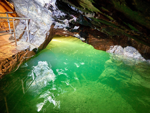 Bij het ondergrondse meer Ein beleuchteter, smaragdgrüner See liegt unter beeindruckenden Gesteinsformationen in einer Höhle.An illuminated, emerald-green lake lies beneath impressive rock formations in a cave.Pod působivými skalními útvary v jeskyni leží osvětlené, smaragdově zelené jezero.Pod imponującymi formacjami skalnymi w jaskini znajduje się oświetlone, szmaragdowozielone jezioro.Een verlicht, smaragdgroen meer ligt onder indrukwekkende rotsformaties in een grot.Un lago illuminato di colore verde smeraldo si trova sotto imponenti formazioni rocciose in una grotta.