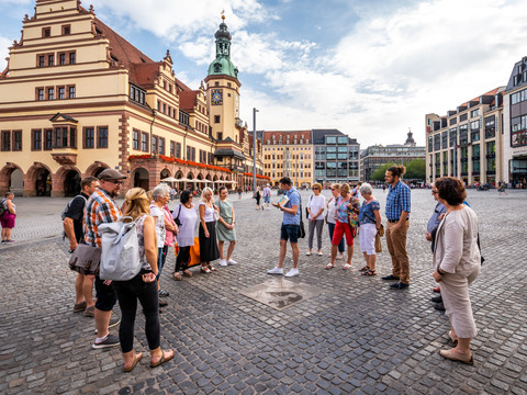 Wycieczka grupowa po rynku w Lipsku przed Starym Ratuszem - zwiedzanie historii Lipska z przewodnikiem Latem grupa ludzi stoi w kręgu na lipskim rynku przed Starym Ratuszem.