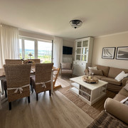 haus_ella_wohnzimmer2.jpg Wohnzimmer mit Sofa und Esstisch eingerichtet im Landhausstil