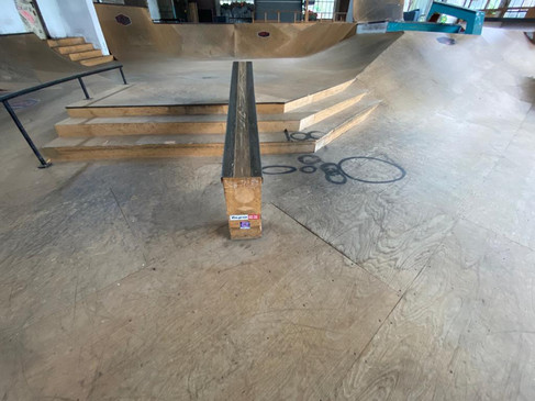 Eine Skatehalle mit Rampen, Treppen und Geländer, die vielfältige Skatemöglichkeiten bietet.