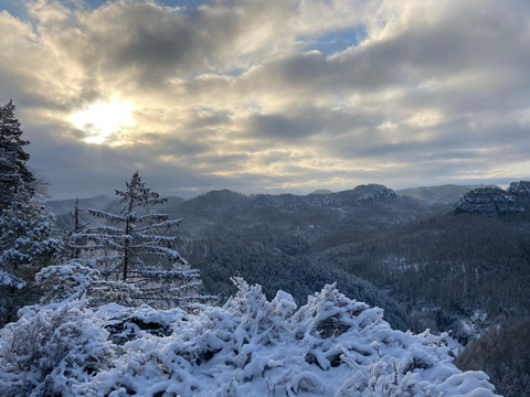Ausblick-vom-Großstein-(c)-Nicole-Hesse.jpg Verschneite Landschaft mit schneebedeckten Bäumen im Vordergrund, bewölkter Himmel und Sonnenstrahlen im Hintergrund, ruhige Winteratmosphäre.Snowy landscape with snow-covered trees in the foreground, cloudy sky and rays of sunshine in the background, peaceful winter atmosphere.Zasněžená krajina se zasněženými stromy v popředí, zatažená obloha a sluneční paprsky v pozadí, klidná zimní atmosféra.Śnieżny krajobraz z ośnieżonymi drzewami na pierwszym planie, zachmurzone niebo i promienie słońca w tle, spokojna zimowa atmosfera.Besneeuwd landschap met besneeuwde bomen op de voorgrond, bewolkte lucht en zonnestralen op de achtergrond, vredige wintersfeer.Paesaggio innevato con alberi innevati in primo piano, cielo nuvoloso e raggi di sole sullo sfondo, tranquilla atmosfera invernale.