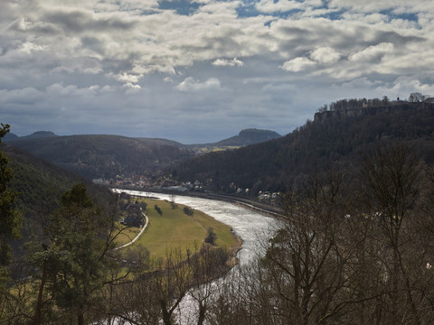 Thürmsdorf Ausblick auf die Elbe Flusslandschaft mit bewaldeten Hügeln, einer Festung auf einem Hügel rechts und einem Dorf am Flussufer unter bewölktem Himmel.River landscape with wooded hills, a fortress on a hill to the right and a village on the riverbank under a cloudy sky.Říční krajina se zalesněnými kopci, tvrzí na kopci vpravo a vesnicí na břehu řeky pod zataženou oblohou.Krajobraz rzeki z zalesionymi wzgórzami, twierdzą na wzgórzu po prawej stronie i wioską na brzegu rzeki pod zachmurzonym niebem.Rivierlandschap met beboste heuvels, een fort op een heuvel rechts en een dorp aan de oever van de rivier onder een bewolkte hemel.Paesaggio fluviale con colline boscose, una fortezza su una collina a destra e un villaggio sulla riva del fiume sotto un cielo nuvoloso.
