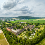 Hoexter-Kloster Corvey-Stadt Hoexter-D. Ketz-2023-442.jpg Luftaufnahme des Klosters Corvey in Höxter, umgeben von Grünflächen und einem Fluss.