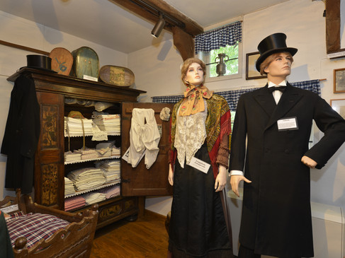 Museale Schlafstube im Grönegau-Museum mit historischem Wäscheschrank und Figuren in Tracht.