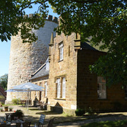 Burg Ravensberg Burg Ravensberg mit massiven Steinturm und restaurierter Fassade, umgeben von grünen Bäumen.
