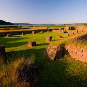 Klosterruine tom Roden, Höxter Überreste einer Klosterruine in Höxter, umgeben von Wiesen und sanften Hügeln bei Sonnenuntergang.