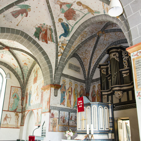 Altar Historische Kapelle mit bemalter Gewölbedecke, farbenfrohen Fresken und einer antiken Orgel.