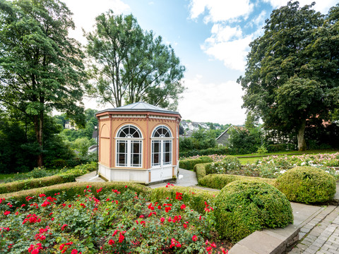 Hückeswagen Ein eleganter Pavillon im Rosengarten, umgeben von blühenden Rosen und gepflegten Hecken.