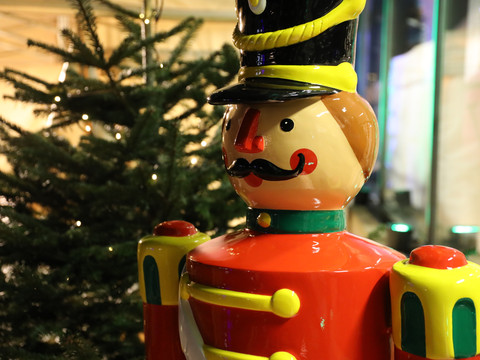 Weihnachtsmarkt Schloss Eulenbroich Nussknackerfigur in Uniform neben einem geschmückten Weihnachtsbaum, festliche Dekoration.