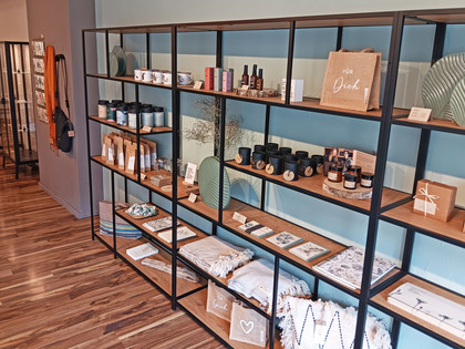 G-Werk_Deko.jpg Langes Regal mit hübsch dekorierter Ware: Textilien, Kerzen und vieles mehr