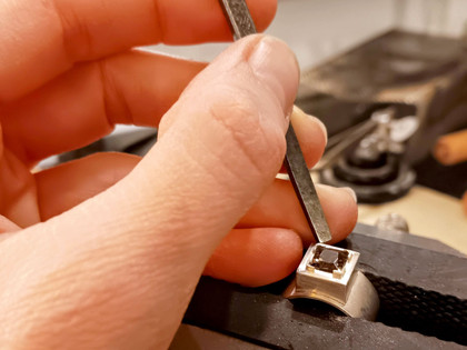 G-Werk_Handarbeit.jpg Ein Edelstein wird in einen Ring eingesetzt