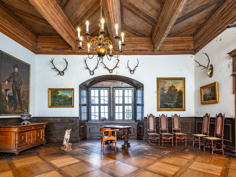 Ausstellungsraum Schloss Rochsburg - Schlösser der Leipzig Region Ein Ausstellungsraum des Museums mit Einrichtungsgegenständen thematisch zur Jagd passend, wie Geweihe, ein ausgestopfter Fuchs und Gemälde aus der Zeit des 16. bis 19. Jahrhunderts auf Schloss Rochsburg in der Leipzig Region, Ausflugsziel