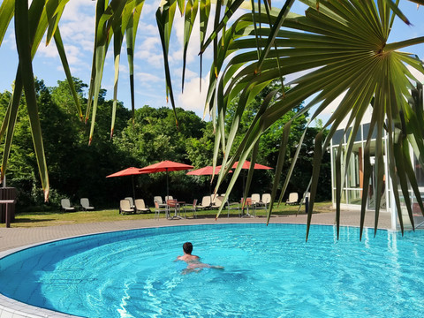 Sauna world at HEIDE SPA Bad Düben - Wellness in Leipzig and the region A man swims in the pool of the sauna area in the Heide Spa Bad Düben in sunny weather, excursion, wellness, leisure