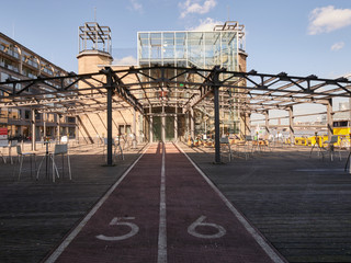 Museumsterrasse (21).jpg Moderner Pavillon mit Glasfassade, flankiert von zwei Türmen und umgeben von Metallstruktur.</p>Modern pavilion with glass façade, flanked by two towers and surrounded by metal structure.</p> <p