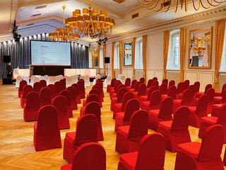 Großer Saal Eleganter, leerer Konferenzraum mit roten Stühlen, goldenen Kronleuchtern und Holzboden.</p>Elegant, empty conference room with red chairs, golden chandeliers and wooden floor.</p> <p