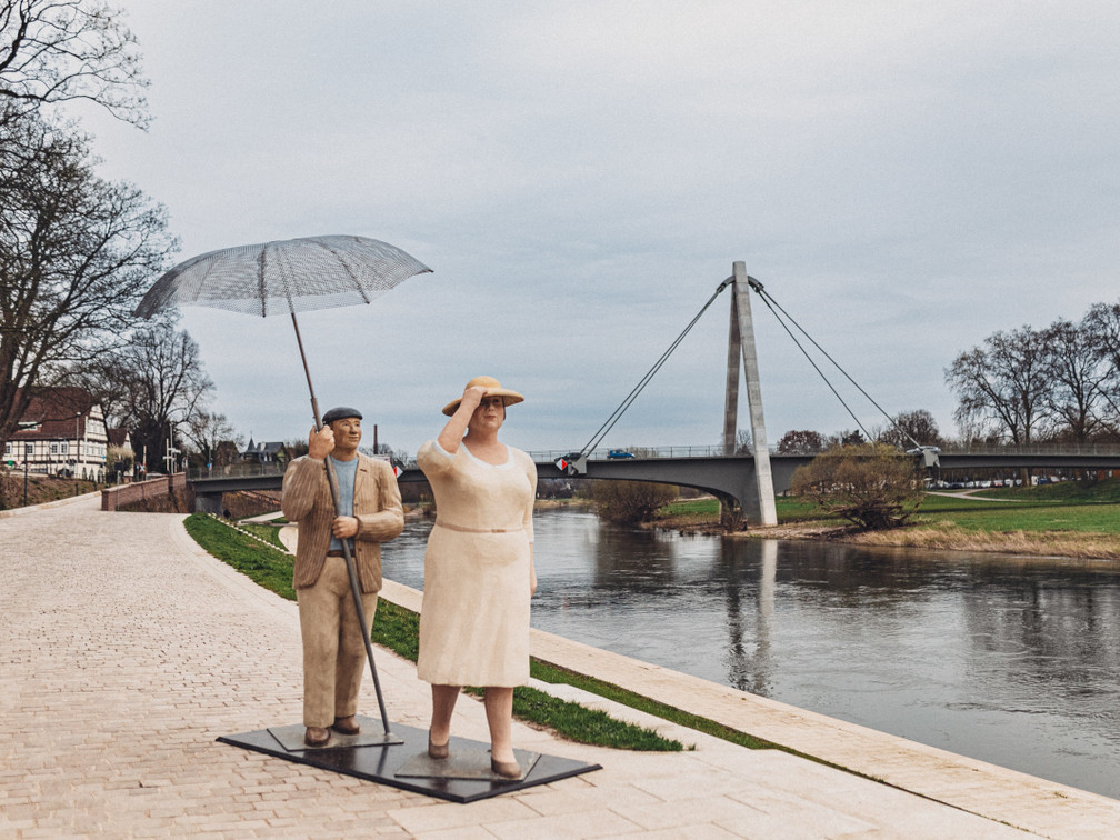 02_2024_03_Huxarium_CWarneke.jpg Überdimensional großes Skulpturenpärchen der bekannten Alltagsmenschen von den Lechner Künstlerinnen an der Weserpromenade, im Hintergrund die Weserbrücke.
