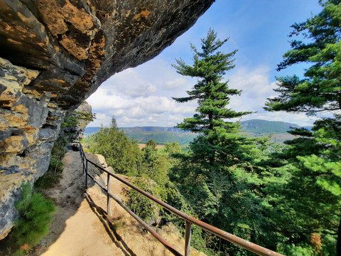 Zirkelstein mit Blick zum Winterberg Unter einem Felsvorsprung bietet sich ein weiter Blick auf grüne Wälder und entfernte Berge.