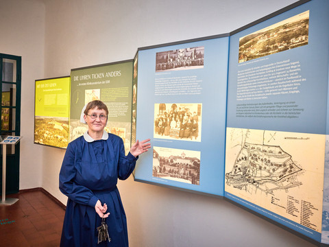 Führung in den MHS Eine Guide in historischer Kleidung erklärt eine informative Ausstellung zu regionaler Geschichte.