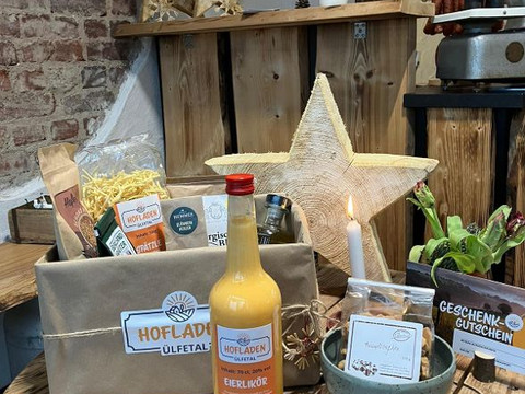 Hofladen Ülfetal  Ein rustikaler Hofladen präsentiert regionale Produkte wie Eierlikör, Nudeln und Kerzen, umgeben von Holzdeko.