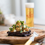 NeoBiota Ein kunstvoll angerichtetes Gourmetgericht mit frischen Kräutern und einem köstlichen Getränk im Hintergrund. An artfully arranged gourmet dish with fresh herbs and a delicious drink in the background.