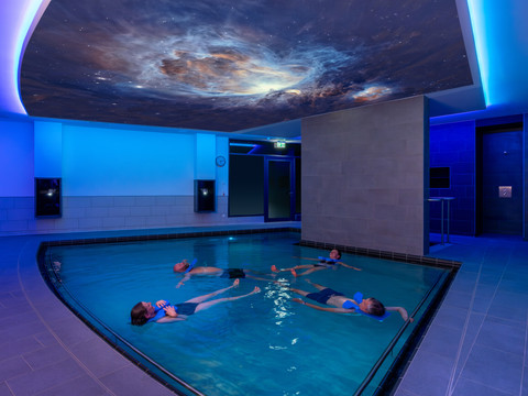 Solebad im Gesundheitsbad ACTINON Bad Schlema Menschen entspannen im beleuchteten Solebad unter einem Deckenbild mit kosmischen Motiven.People relax in the illuminated brine bath under a ceiling painting with cosmic motifs.Lidé relaxují v osvětlené solné lázni pod stropní malbou s kosmickými motivy.Ludzie relaksują się w podświetlanej wannie solankowej pod malowidłem sufitowym z kosmicznymi motywami.Mensen ontspannen in het verlichte pekelbad onder een plafondschildering met kosmische motieven.Le persone si rilassano nel bagno salino illuminato sotto un soffitto dipinto con motivi cosmici.