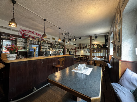Zur Quelle der Strunde - Innenansicht Gemütliche Bar mit Holztresen, rustikaler Einrichtung und einladender Atmosphäre im Innenraum.