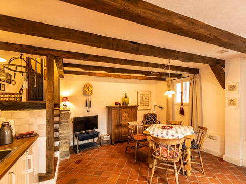 Ferienwohnung Hof Tüschenbonnen Gemütlich eingerichtetes Wohnzimmer einer Landhausküche mit Holzbalken, Esstisch und antiker Dekoration.
