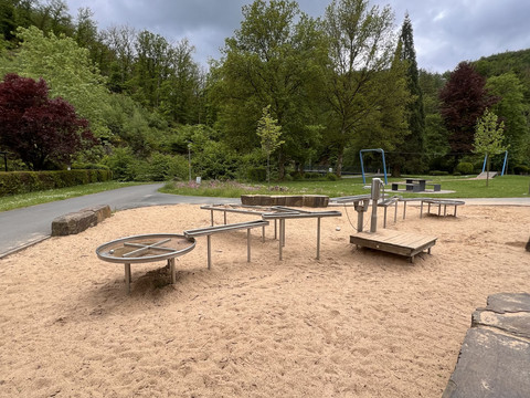 Wasserspielplatz im Kurpark Spielplatz mit Wasser- und Sandspielanlage, umgeben von Bäumen und Wegen im Grünen.
