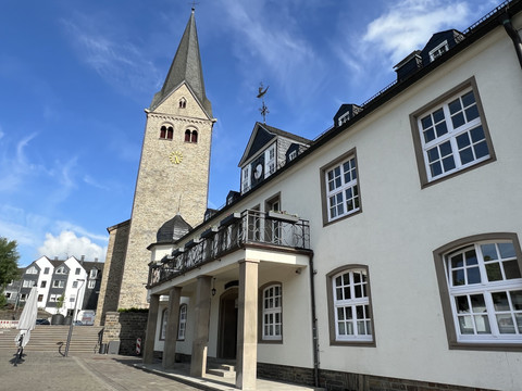 ev. Kirche mit Rathaus Kirchturm und historisches Gebäude in Wiehl, unter blauem Himmel mit ein paar weißen Wolken.