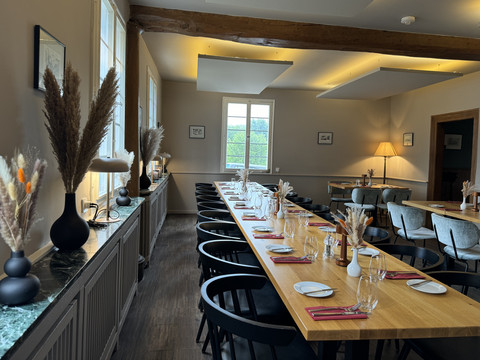 Zum Haus Olpe - Innenansicht Ein modernes Restaurant mit elegant gedeckten Tischen, dekoriert mit kunstvollen Trockenblumenarrangements.