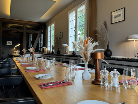 Zum Haus Olpe - Innenansicht  Eleganter, länglicher Esstisch in modernem, gemütlichem Ambiente, eingedeckt mit Gläsern und Geschirr.