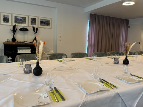 Zum Haus Olpe - Innenansicht Veranstaltungsraum  Ein festlich gedeckter Tisch in einem eleganten Raum mit weißen Tischdecken und dekorativen Vasen.