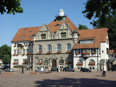 Rathaus Bergisch Gladbach Historisches Rathaus mit roten Ziegeldächern und Blumendekoration auf einem sonnigen Marktplatz.