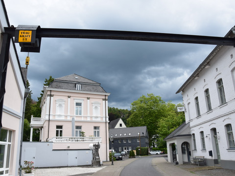 Hoffnungsthaler Hammer <p>Historische Gebäude in einer ruhigen Straße unter bewölktem Himmel in Rösrath, Deutschland.</p>