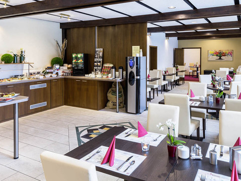 Frühstücksraum.jpg Helles Restaurant mit gedeckten Tischen, Frühstücksbuffet und moderner Einrichtung.