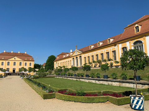 Barockgarten Großsedlitz Gebäude des Barockgarten Großsedlitz, im Vordergrund Rasen, Beete und Bäume, bei Sonnenschein.Building of the Grosssedlitz Baroque Garden, lawn, beds and trees in the foreground, in the sunshine.Budova barokní zahrady Grosssedlitz, trávník, záhony a stromy v popředí, na slunci.Budynek ogrodu barokowego Grosssedlitz, trawnik, rabaty i drzewa na pierwszym planie, w promieniach słońca.Gebouw van de baroktuin Grosssedlitz, gazon, perken en bomen op de voorgrond, in de zon.Edificio del Giardino Barocco di Grosssedlitz, prato, aiuole e alberi in primo piano, alla luce del sole.