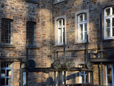 LVR-Industriemuseum Kraftwerk Ermen & Söhne <p>Historische Fassade eines alten Steingebäudes mit Fenstern und mechanischen Teile im Vordergrund.</p>