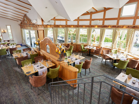 Derichsweiler Hof Einladendes Restaurant mit Holzdetails, großen Fenstern und gemütlich eingedeckten Tischen in natürlicher Umgebung.