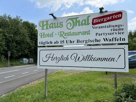 Haus Thal - Ansicht Straßenschild Hinweisschild eines Restaurants mit Biergarten und Bergischen Waffeln an einer Landstraße.
